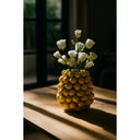 Yellow lemon vase with white flowers on a wooden surface