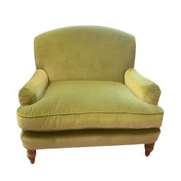 A gold velvet coloured armchair with wooden feet.