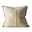 Beige pillow with textured trim on a white background