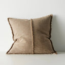 Brown pillow with frayed edges on a light gray background