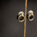 Pair of gold cabinet knobs on a black painted cabinet