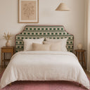 Bedroom with a bed featuring a green and white patterned headboard, white bedding, and decorative pillows.