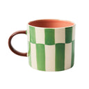 Mug with green and white checkered pattern on a white background