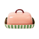 Pink ceramic butter dish with green and white striped base on a white background