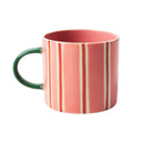 Mug with pink, red and white striped design on a white background