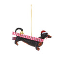 Decorative dachshund ornament with a pink ribbon and bell on a white background