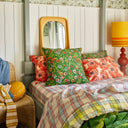 Bedroom with colorful pillows and a lamp on a wooden headboard.