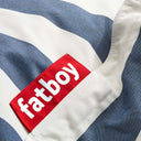 Close-up of a red Fatboy logo on a blue and white striped fabric background