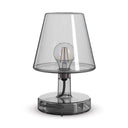 Grey transparent glass table lamp on a white background