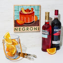 Negroni ingredients including bottles of Impari and Cinzano, a glass with orange slices, and a Negroni-themed decorative plaque.