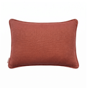 A rectangular lumbar pillow in a textured rust-orange fabric, featuring piped edges and a small woven brand tag on the lower left, set against a plain white background.