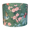 Fabric lampshade with floral and bird design on a green background