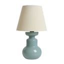 Table lamp with a light green base and beige shade on a white background