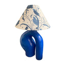 Blue lamp with a decorative lampshade on a white background