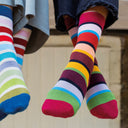 Colorful striped socks being worn on a neutral background
