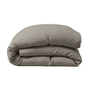 Folded beige comforter on a white background