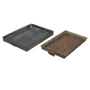 Two metal trays, one black and one rust-colored, on a white background