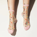 Sheer socks with colorful confetti design and pink accents on a white background
