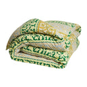 Green and yellow patterned comforter on a white background