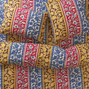 Close-up of colourful bedding set-up with red, blue, and yellow floral patterns.