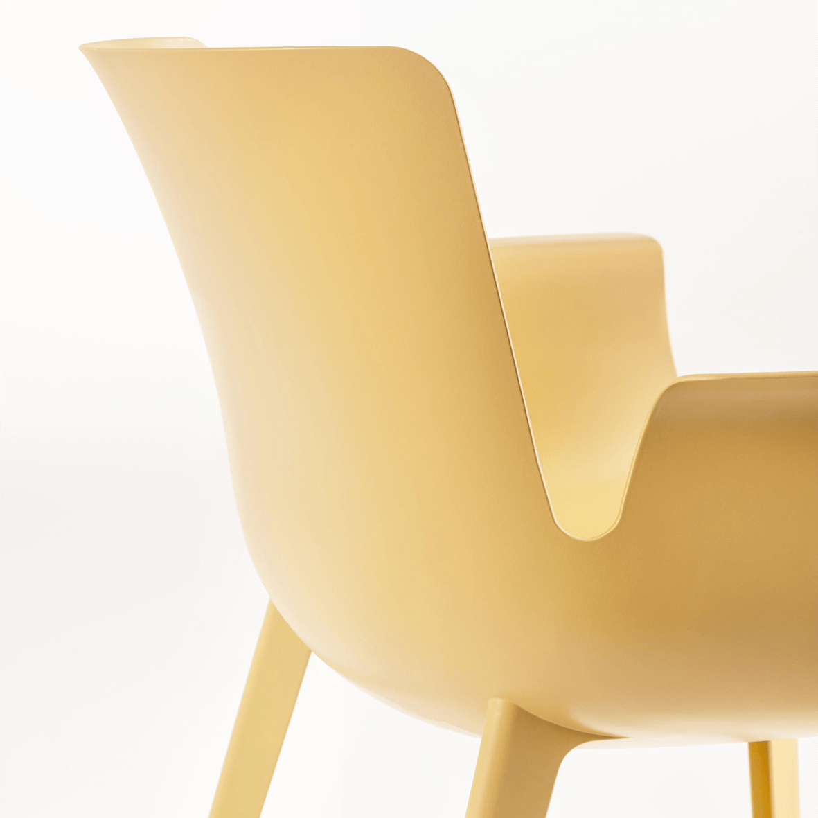 The back of a mustard Piuma armchair by Kartell.