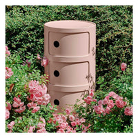 A round pink side drawer with three draws in the Componibili range by Kartell.