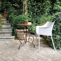 A Dr. no white armchair by Kartell in garden.