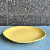 Side on view of a yellow ceramic plate.
