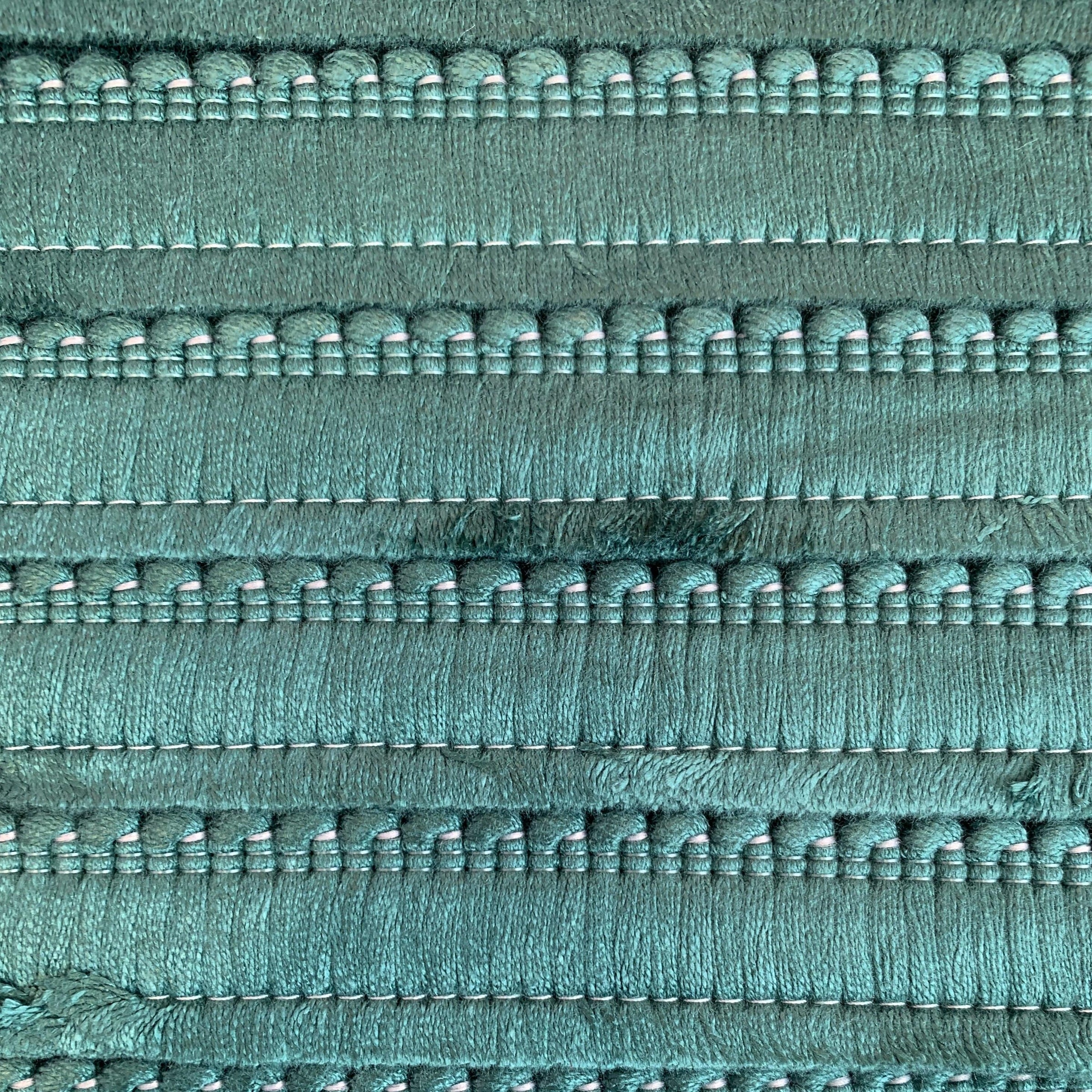 A close up of an emerald green cushion fringe.