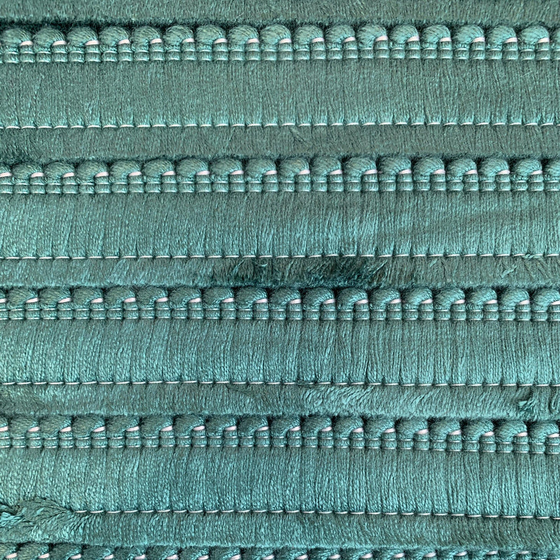 A close up of an emerald green cushion fringe.