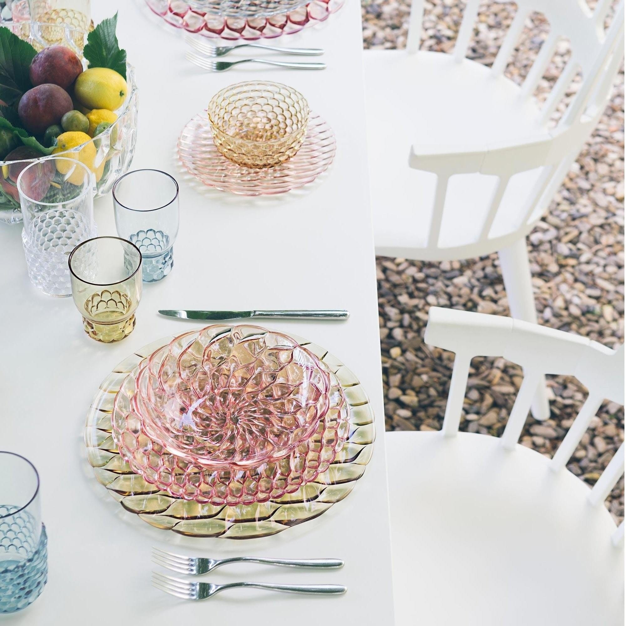 The Kartell Jellies tableware range on a white table outdoors.
