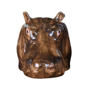 A brown ceramic egg cup designed to look like a hippo, with a simplistic and stylized appearance.