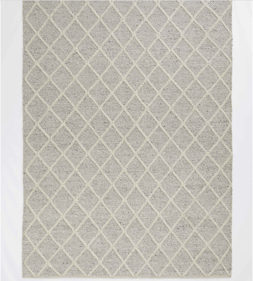 A natural grey coloured rug with white diamond stripes through it.