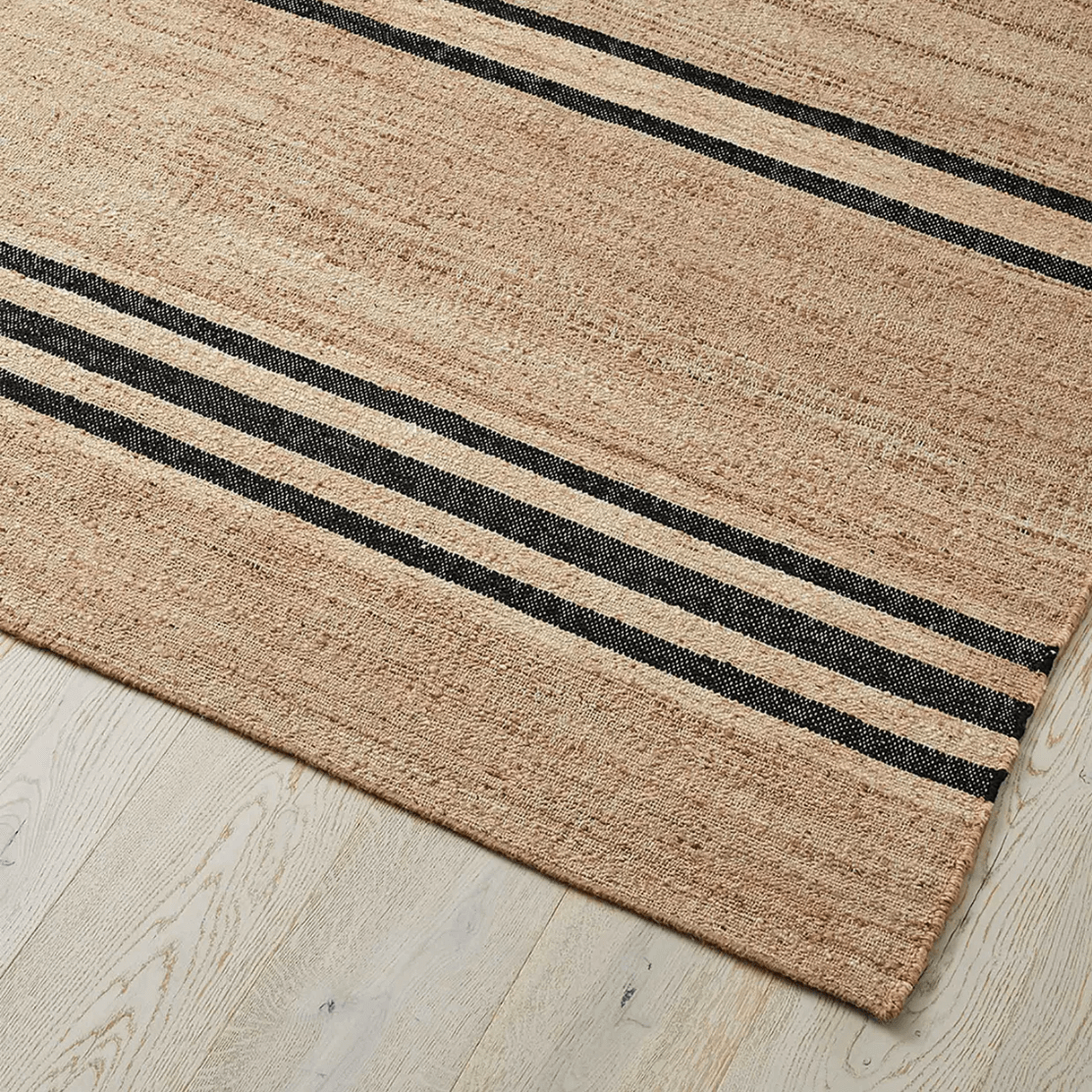 A close up of a natural brown rug with black horizontal stripes.