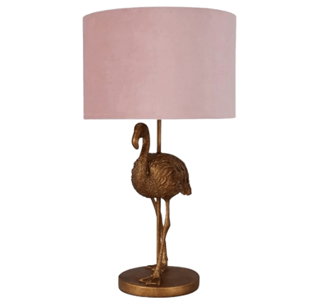 A lampshade with a gold flamingo base and a pink velvet lampshade.