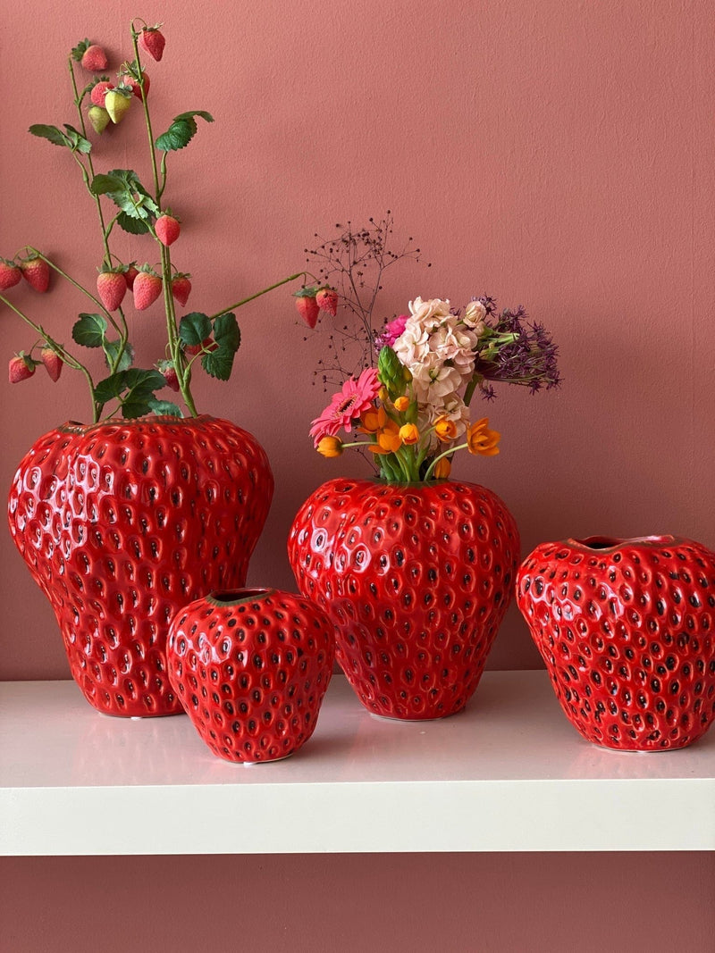 Four 12cm strawberry vases on a white bench