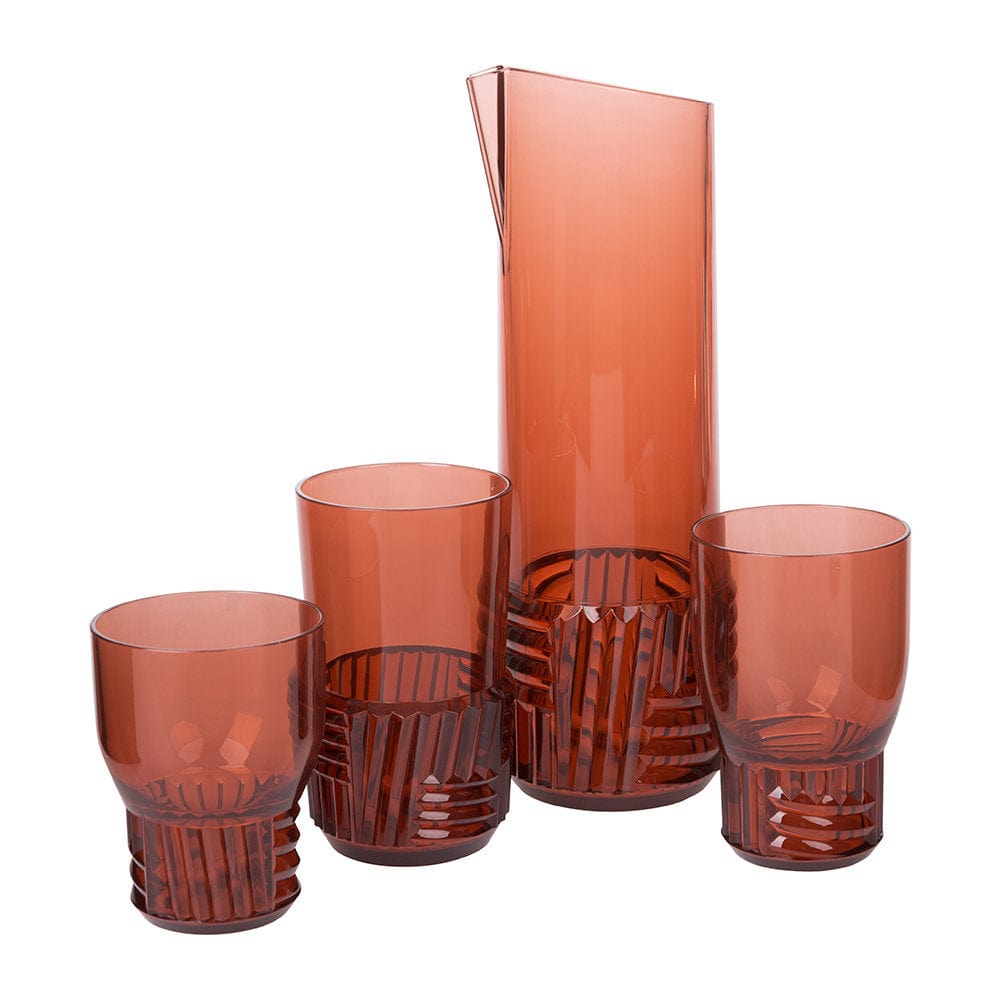 Three water glasses and a carafe, all transparent and in a pink colour.