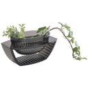 A smoke grey coloured centrepiece with a plant inside it.