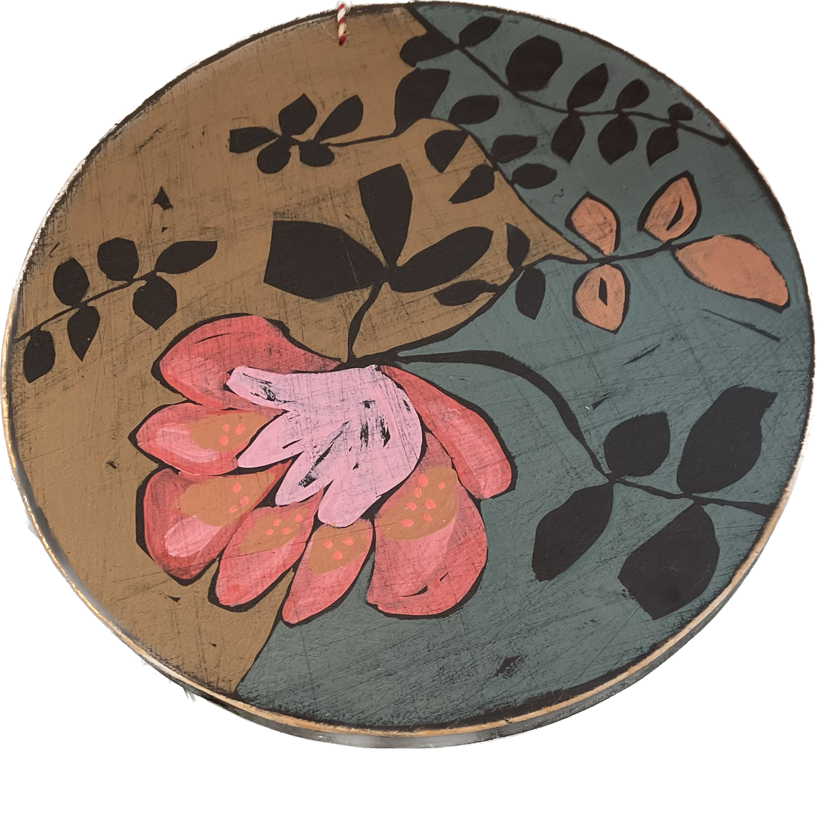 A round piece of wall art with floral paintings.